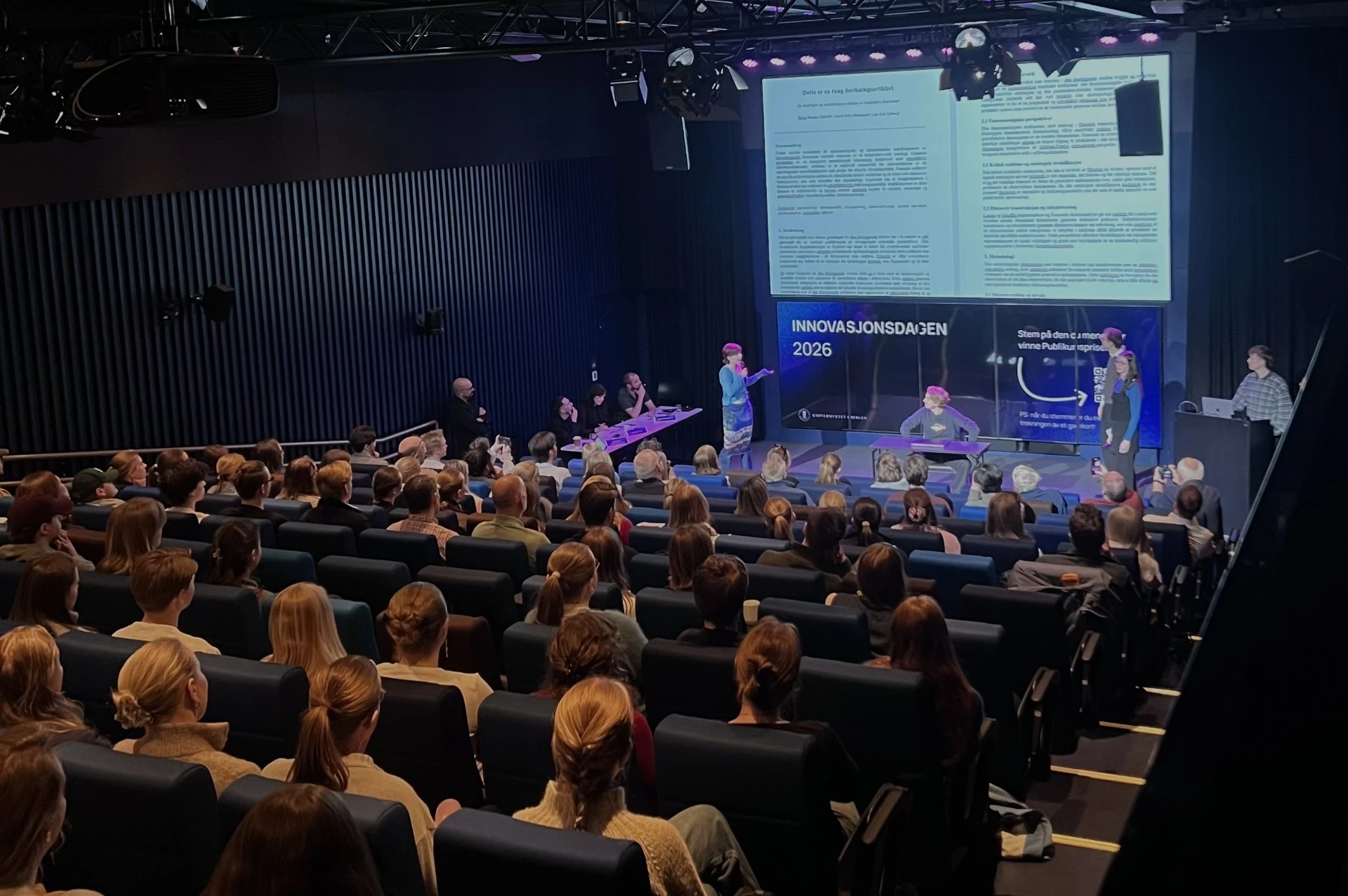 Publikum og jury ser på pitching.